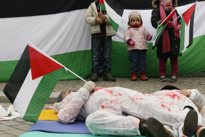 Un palestino pretende simbolizar la sangre para protestar contra la continua operación militar de Israel en la Franja de Gaza