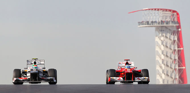 El Ferrari de Fernando Alonso sobrepasa al mexicano Sergio Pérez durante la sesión de entrenamientos en el Gran Premio de Estados Unidos