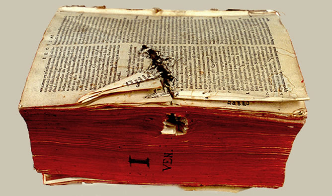 Orificio producido por arma blanca en el lateral, afectando al libro