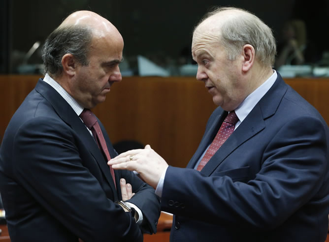 El ministro de Economía español de Guindos saluda al ministro irlandés Noonan durante una reunión en Bruselas