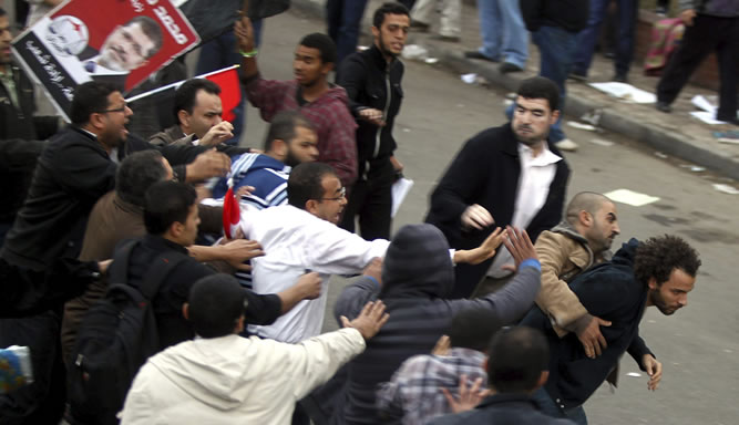 Seguidores del presidente egipcio, Mohamed Mursi, y de los Hermanos Musulmanes, pelean con los opositores que habían acampado frente al Palacio Presidencial de El Cairo