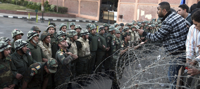 Varias personas se encaran con las fuerzas de seguirdad durante una manifestación en frente del Palacio presidencial de El Cairo.