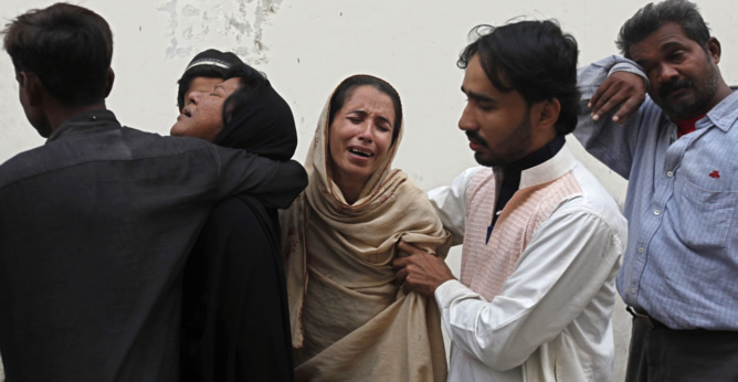 Los miembros de la familia de Nasima Bibi, una de las trabajadoras de la campaña antipolio que ha sido asesinada, afligidos en la morgue del hospital en Karachi
