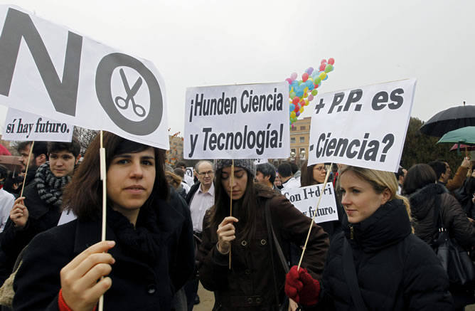 Varios jóvenes sostienen pancartas durante la concentración convocada por el colectivo 'Carta Abierta por la Ciencia', que reúne a sociedades y organizaciones científicas, sindicatos y representantes de la Confederación de Rectores de Universidades Españolas, para exigir un cambio de rumbo en la política