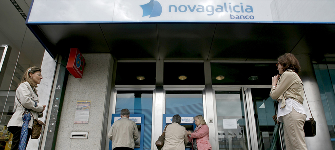Varias personas esperan para sacar dinero de los cajeros de una sucursal de Novagalicia Banco