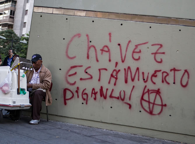 Un hombre vende helados cerca de un graffiti que especula con la muerte del presidente de Venezuela, Hugo Chávez, en Caracas (Venezuela). El grafiti anuncia: "Chávez está muerto, diganlo!"