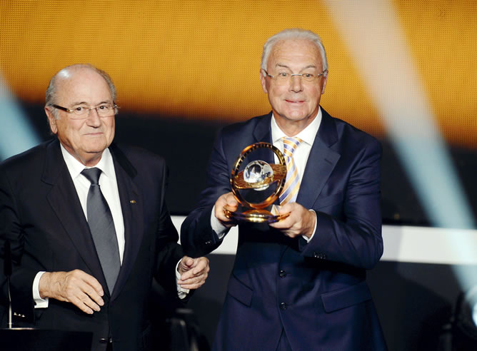 El ex futbolista alemán, Franz Beckenbauer, posa con el trofeo presidencial de la FIFA entregado por el presidente de la FIFA, Joseph S. Blatter.
