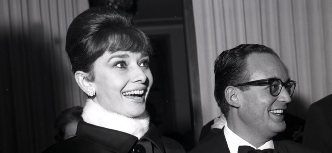 Fotografía de archivo tomada el 22 de noviembre de 1961 que muestra al productor de cine italiano Dino De Laurentiis junto a la actriz británica Audrey Hepburn.