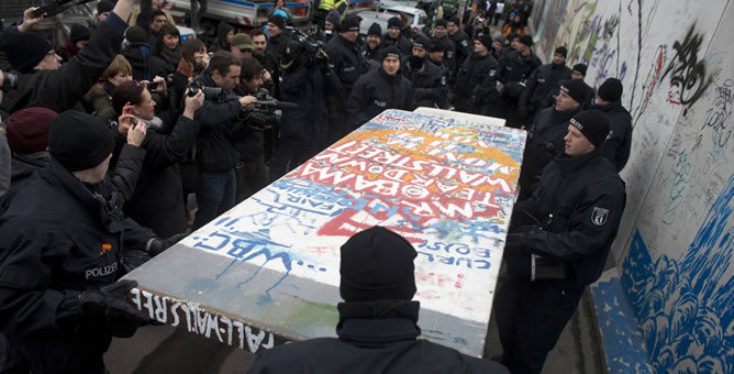 La policía retira una copia de un manifestante de un segmento del Muro de Berlín en una manifestación en contra de la eliminación de la East Side Gallery