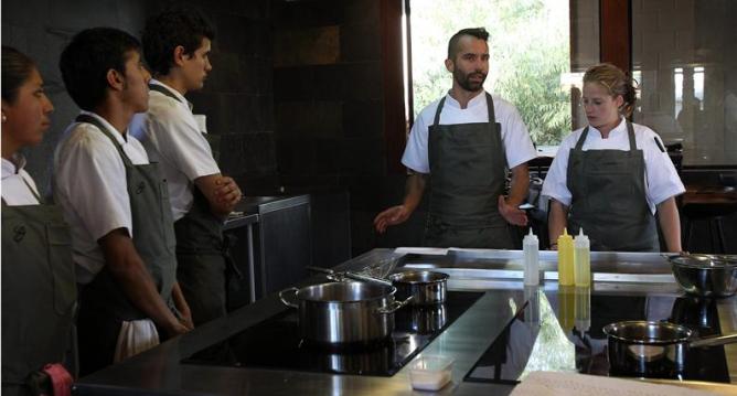 El chef venezolano Michelangelo Cestari (3d) y la danesa Kamilla Seidler (d) dan instrucciones a bolivianos que trabajan en el restaurante Gustu de La Paz.