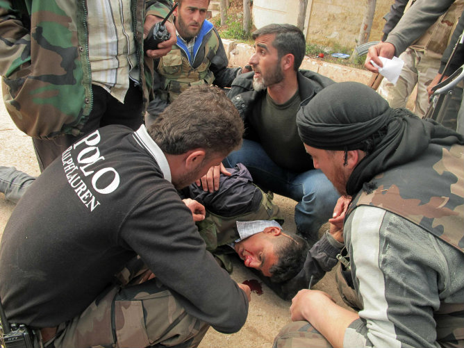 Un grupo de hombres atiende a un herido cerca de Aleppo