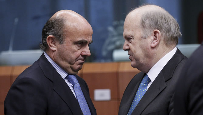 El ministro español de Economía y Competitividad, Luis de Guindos conversa con su homólogo irlandés Michael Noonan, a su llegada a la reunión de los ministros de Finanzas de la eurozona celebrada en Bruselas