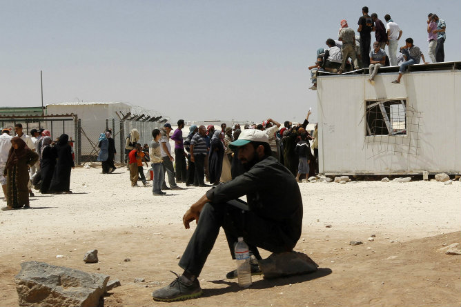 Sirios esperan para recibir la ayuda y raciones en el campamento de refugiados de Al Zaatri, en la ciudad jordana de Mafraq.