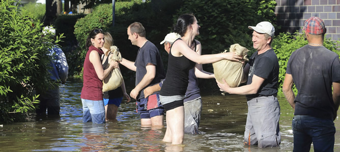 Unos voluntarios hacen una cadena humana para transportar sacos de tierra en una calle inundada de Magdeburgo, Alemania, tras el desbordamiento del río Elba