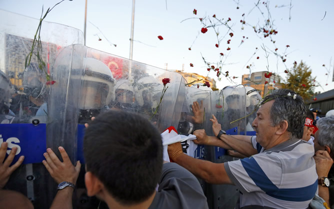 Los indignados turcos lanzan claveles rojos al aire cuando se cumple una semana del primer desalojo violento del parque Gazi.