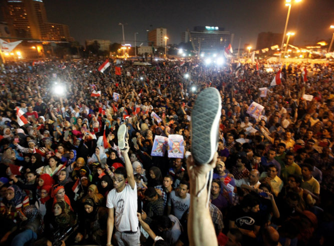 Los opositores del presidente egipcio levantan sus zapatos para manifestar su ira