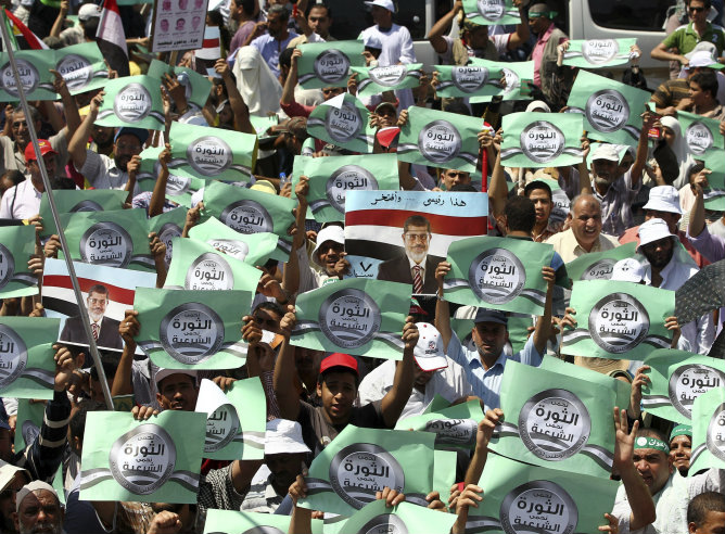 Varios activistas egipcios enseñan pancartas con eslóganes en defensa del presidente egipcio