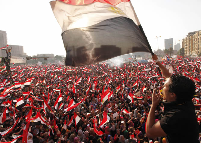 Varios egipcios despliegan sus banderas nacionales durante la protesta convocada contra el presidente Mohamed Mursi frente al palacio presidencial de El Cairo