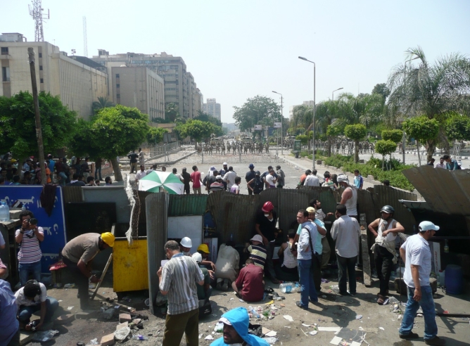 Un grupo de seguidores de Mursi y militares se encuentran separados por una barrera de cinco metros mientras aumenta la tensión entre ambos grupos.