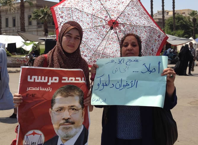 Dos mujeres sostienen un cartel con la foto del presidente derrocado, Mohamed Mursi, en apoyo a él
