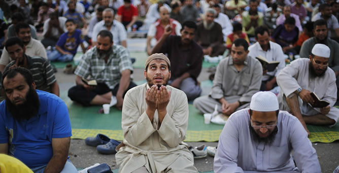 Seguidores del depuesto presidente Mursi rezan antes de comer en el primer día de Ramadán