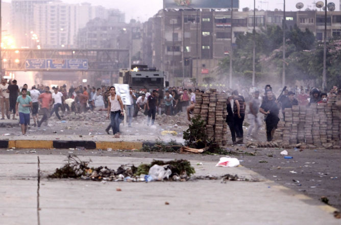 Los opositores del presidente egipcio, Mohamed Mursi depuesto tiran piedras a sus partidarios durante los enfrentamientos en El Cairo