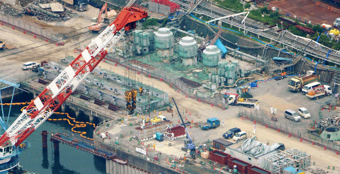 Una vista aérea muestra los trabajadores de la construcción de una barrera de tierra para detener el escape de agua radiactiva en el mar en la central de Fukushima