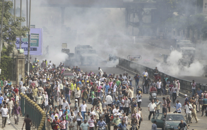 Seguidores de Mursi desalojados de las acampadas corren delante de tanques