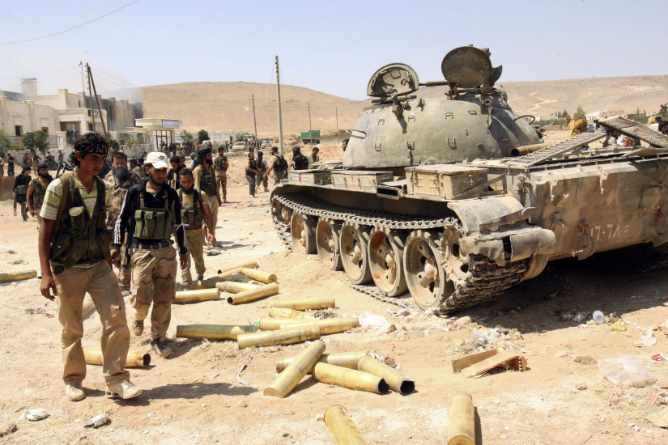Combatientes del Ejército sirio inspeccionando municiones y un depósito que pertenecía a las fuerzas leales al presidente de Siria