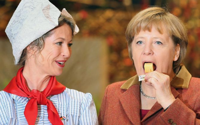 La canciller alemana degusta un trozo de queso durante la apertura de la Semana Verde Internacional de Berlín, el pasado 18 de enero.