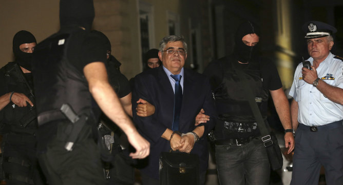 El líder del partido de extrema derecha Amanecer Dorado escoltado por la policía anti-terrorista en un tribunal en Atenas. A espera de juicio, Nikos Mijaloliakos está acusado de pertenencia a un grupo criminal.