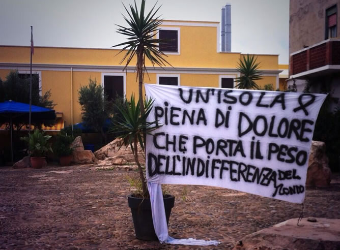 Una pancarta que reza: "Una isla llena de dolor que lleva el peso de la indiferencia del mundo."