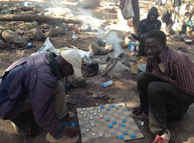 Un grupo de subsaharianos pasan el rato en el campamento improvisado