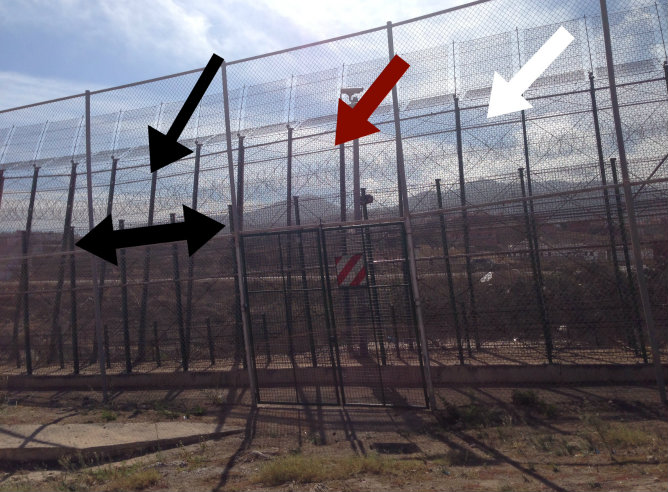 Las flechas señalan las cuchillas y la valla "antitrepa" colocada a lo largo de casi todo el perímetro en el lado marroquí