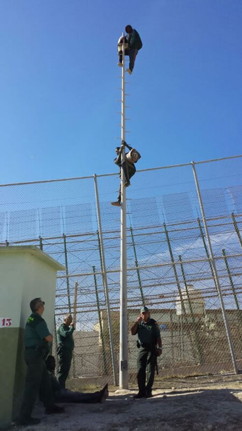 Dos inmigrantes subsaharianos se encaraman a un poste durante dos horas en su intento de entrada a Melilla
