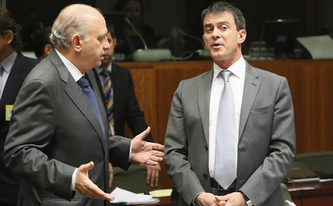 El ministro español de Interior, Jorge Fernández Díaz (i), conversa con su homólogo francés, Manuel Valls, durante la reunión del Consejo de ministros de Interior de la Unión Europea