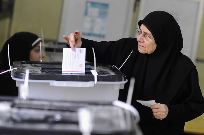 Una mujer emite su voto en un centro de votación durante el referéndum sobre la nueva constitución de Egipto