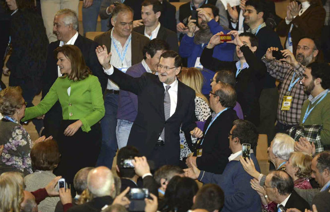 El presidente del Gobierno, Mariano Rajoy, saluda a los asistentes a su llegada al acto de clausura de la Convención Nacional del PP, junto a la secretaria general del partido, María Dolores de Cospedal