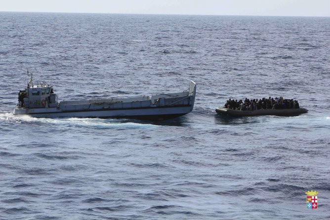 Decenas de inmigrantes esperan a ser rescatados por la Marina italiana sobre una barcaza neumática en aguas cercanas a Lampedusa