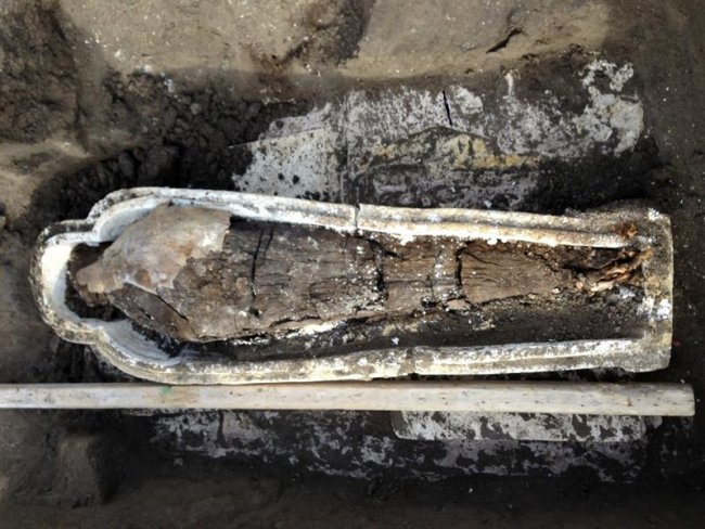 Fotografía facilitada por el Ministerio egipcio de Antigüedades de un sarcófago que contiene la momia de una mujer descubierto por expertos egipcios al norte de El Cairo, junto a tres esqueletos humanos, decenas de amuletos y estatuillas que datan de hace más de 2.500 años