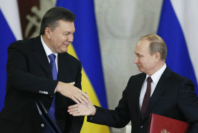 Foto de archivo tomada el 17 de diciembre de 2013 del presidente ruso, Vladímir Putin, mientras estrecha la mano a Víktor Yanukóvich