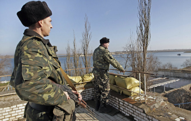 Soldados armados sin identificar, presuntamente rusos, vigilan la entrada de la base naval ucraniana de Novoozerniy, en la península ucraniana de Crimea