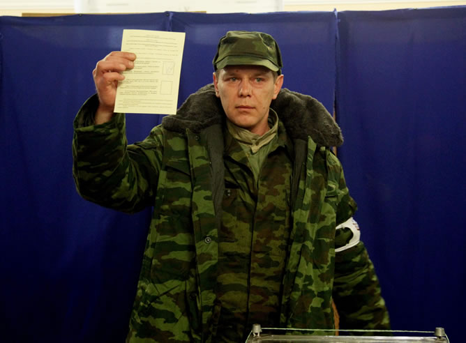 Un miembro de las fuerzas de defensa personal pro-rusos muestra su voto en un colegio electoral en Sebastopol.