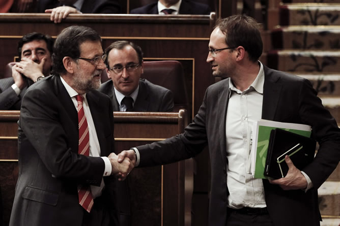 El presidente del Gobierno, Mariano Rajoy, saluda a Joan Herrera, de Iniciativa por Cataluña, durante el pleno del Congreso que ha debatido la proposición de ley del Parlamento de Cataluña