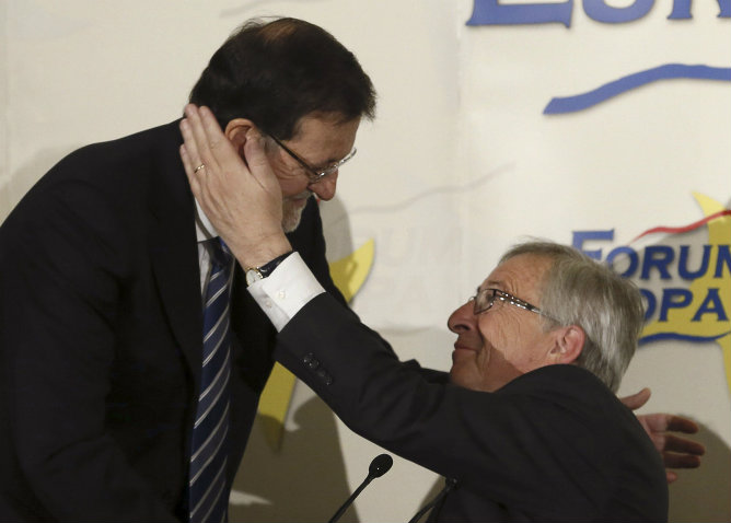 El candidato del Partido Popular Europeo a la Presidencia de la Comisión Europea, Jean-Claude Juncker, junto al presidente del Gobierno, Mariano Rajoy, momentos antes de intervenir en un desayuno informativo organizado por Nueva Economía Fórum