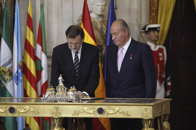 El presidente del Gobierno, Mariano Rajoy, junto al rey Juan Carlos, refrenda la ley orgánica que hará efectiva la abdicación