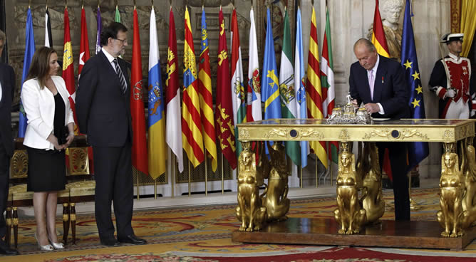 El rey Juan Carlos, junto al presidente del Gobierno, Mariano Rajoy y su mujer durante la firma de la ley orgánica que hará efectiva a medianoche su abdicación