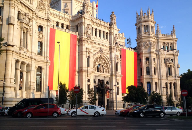El Ayuntamiento de Madrid ya ha desplegado en su fachada dos grandes banderas de España que los nuevos reyes verán a su paso por la plaza de Cibeles.