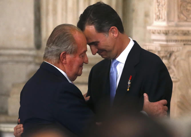 El rey Juan Carlos abraza a su hijo, el futuro rey Felipe VI, después de firmar la ley que hace efectiva su abdicación.