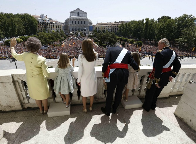 Los reyes, Felipe VI y Letizia, junto a sus hijas, Leonor, princesa de Asturias, y la infanta Sofía, y don Juan Carlos y doña Sofía, saludan desde el balcón central del Palacio de Oriente.